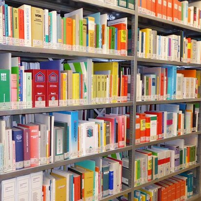 Stahlregal in einer Bibliothek mit Fachbüchern mit buntem Buchrücken