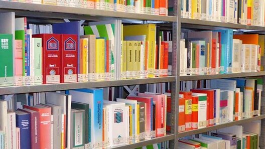 Stahlregal in einer Bibliothek mit Fachbüchern mit buntem Buchrücken